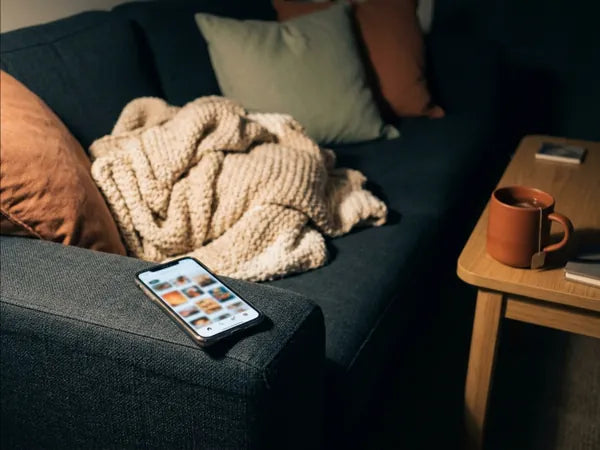 Smartphone sul divano la domenica sera, con lo schermo pieno di idee salvate
