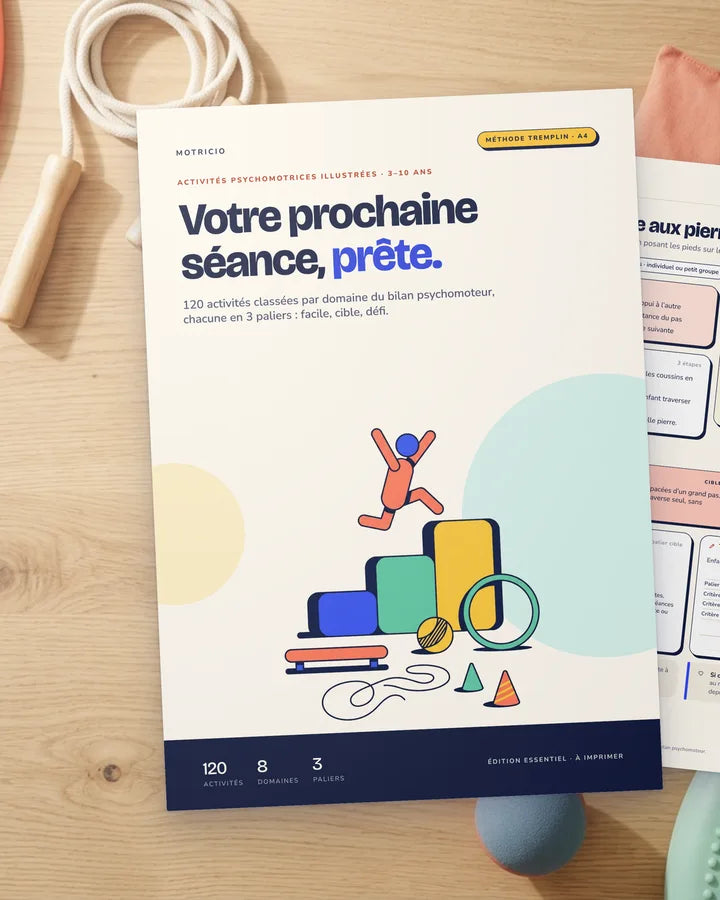 La couverture de Motricio et la fiche EQ-04 « La rivière aux pierres » imprimées, posées sur une table avec des cerceaux, une corde et des sacs lestés