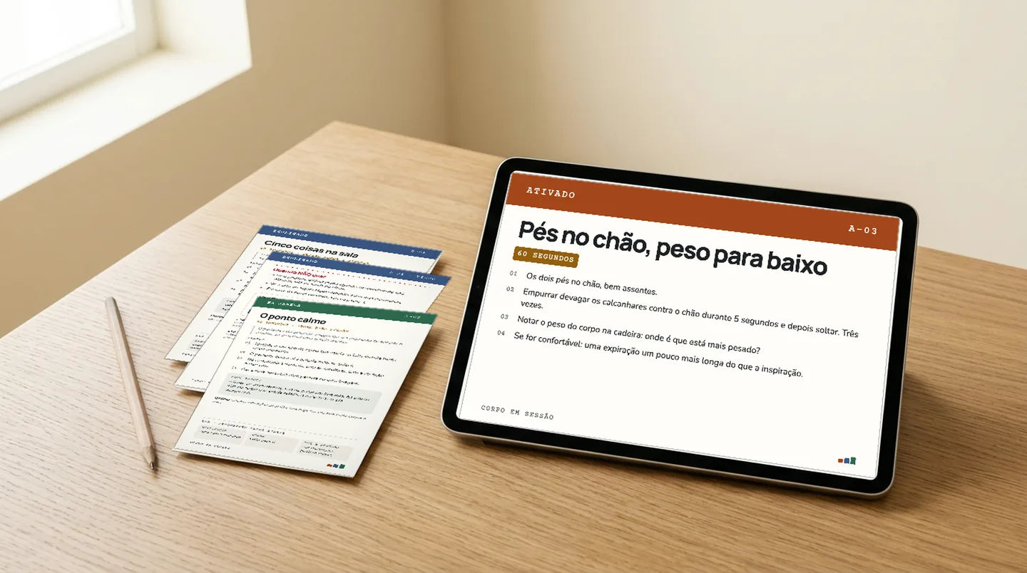 A carta A-03 «Pés no chão, peso para baixo» aberta num tablet, ao lado das cartas impressas D-05 e J-02