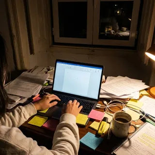 Secretária à noite com portátil, candeeiro e papéis do HACCP espalhados (imagem ilustrativa)